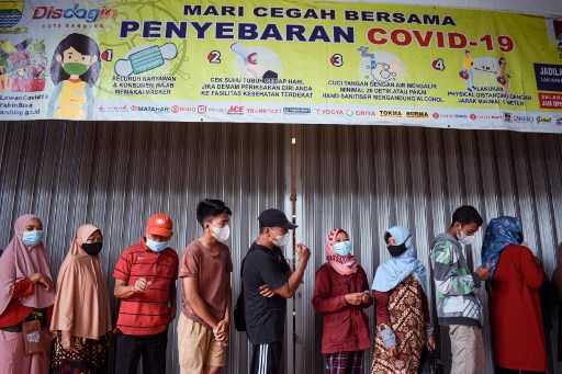 Peoples wearing mask queue to buy cooking oil. Photo: AFP