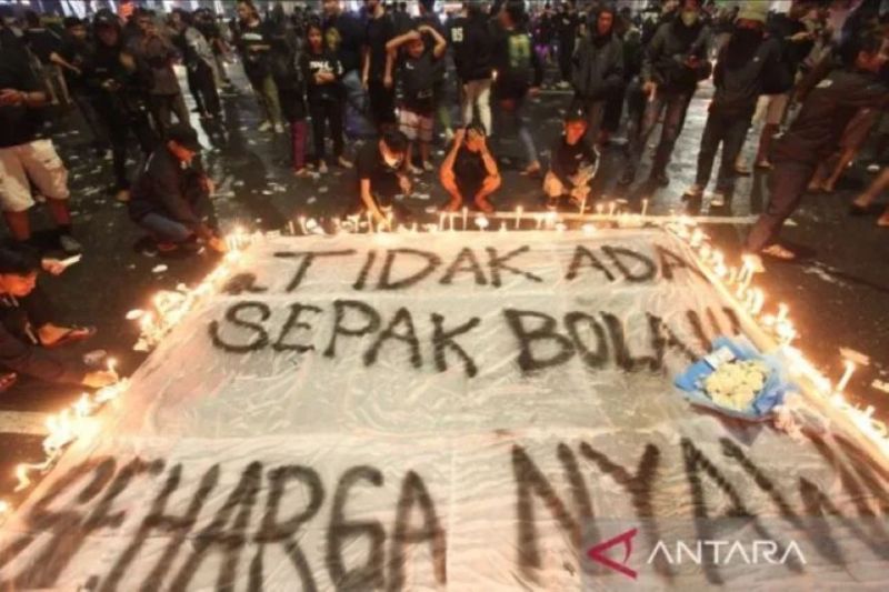  Suporter Persebaya menyalakan lilin saat mengikuti doa bersama di Tugu Pahlawan, Surabaya, Jawa Timur, Senin (3/10/2022). Doa bersama itu untuk para korban tragedi kerusuhan di Stadion Kanjuruhan Malang. (Foto: Antara/Didik Suhartono)