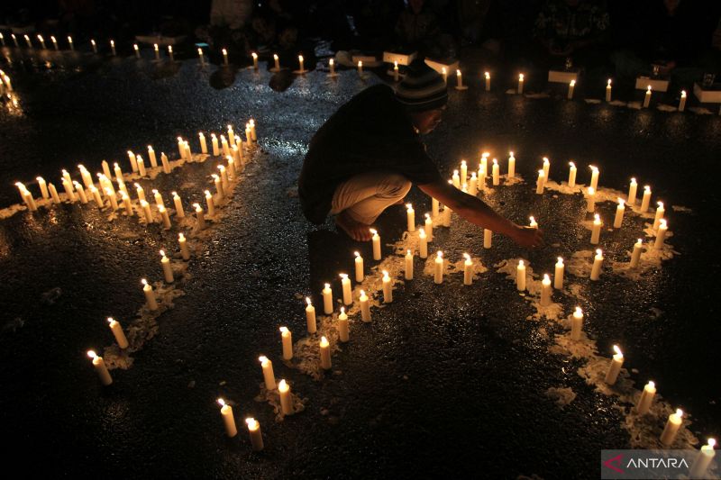 Sejumlah suporter Arema FC (Aremania) menyalakan lilin sesaat sebelum doa bersama di depan stadion Kanjuruhan, Malang, Jawa Timur, Kamis (6/10/2022). (Foto: Antara/Ari Bowo Sucipto/YU)