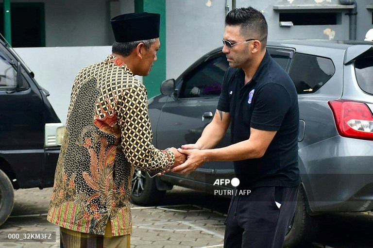 Pelatih Arema, Javier Roca (kanan), bersalaman dengan keluarga korban tragedi Kanjuruhan (AFP/Putri)