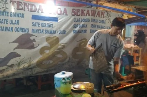 Pak Didi sedang mengipas sate ular. (Foto: Nandhita Nur Fadjriah/Medcom)