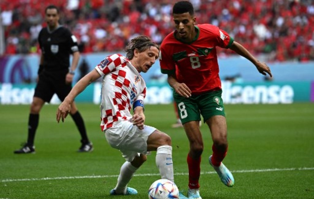 Gelandang Kroasia Luka Modric (kiri) berduel dengan gelandang Maroko Azzedine Ounahi (kanan) di laga perdana penyisihan Grup F Piala Dunia 2022. (Foto: AFP/Ozan Kose)