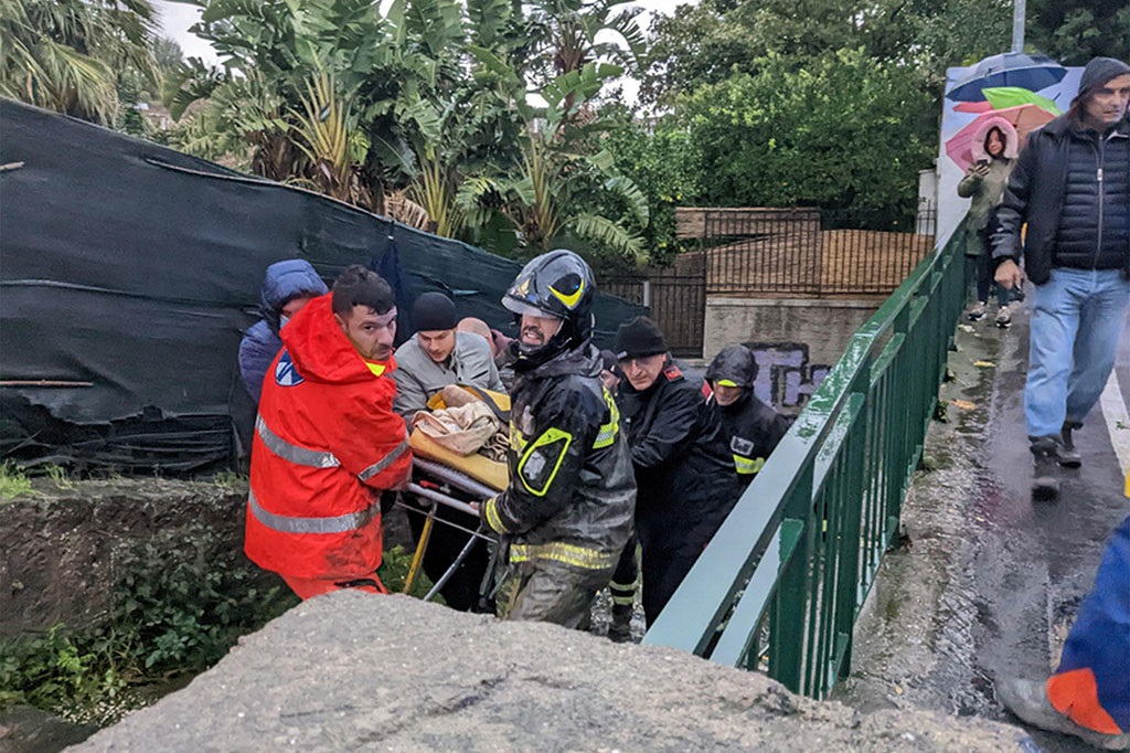 Petugas mengevakuasi seorang korban longsor di Ischia, Italia, 26 November 2022. (AFP PHOTO/ANSA)