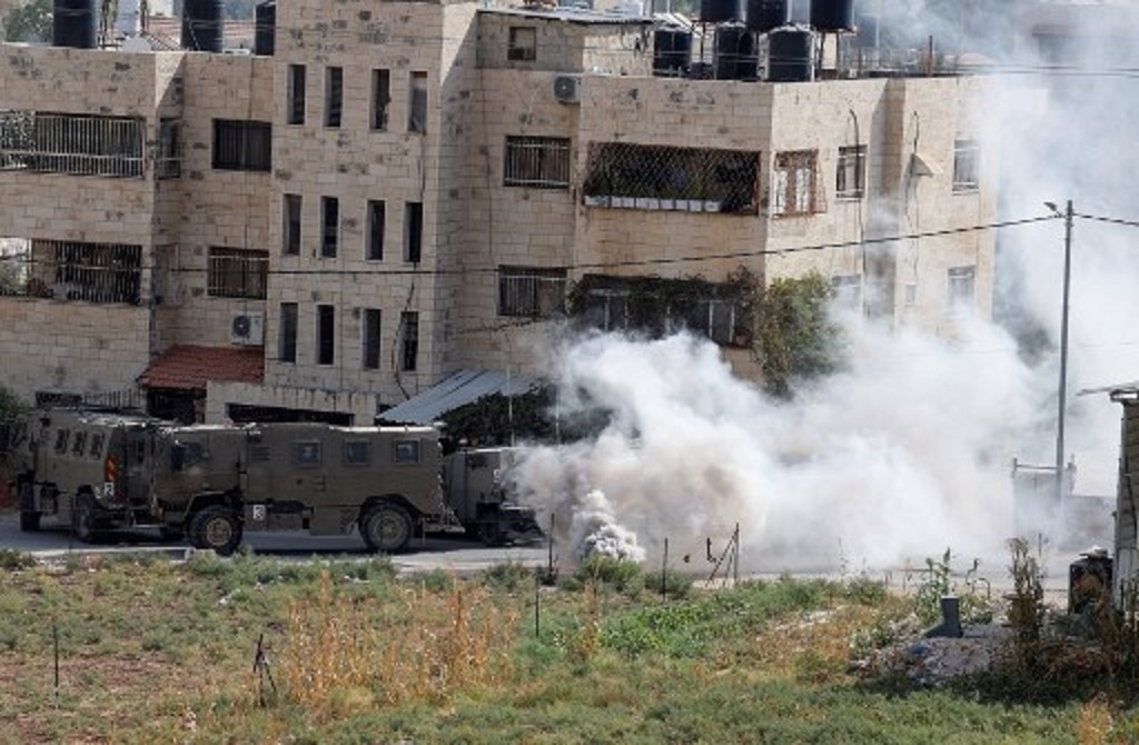 Asap mengepul di sekitar kendaraan Israel di Jenin, Tepi Barat, 8 Oktober 2022. (JAAFAR ASHTIYEH / AFP)