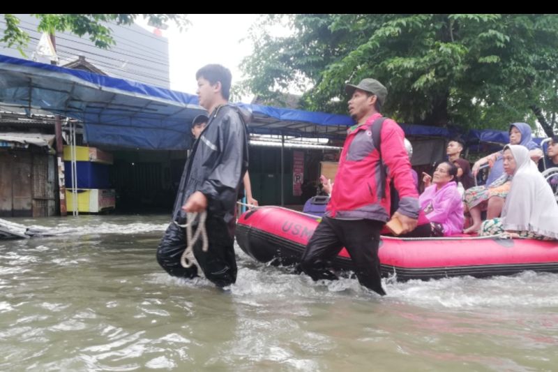 Relawan menarik perahu karet untuk membantu korban banjir yang sakit dan lanjut usia, di Perumahan Tlogosari, Semarang, Sabtu (31/12/2022). (ANTARA/Zuhdiar Laeis)