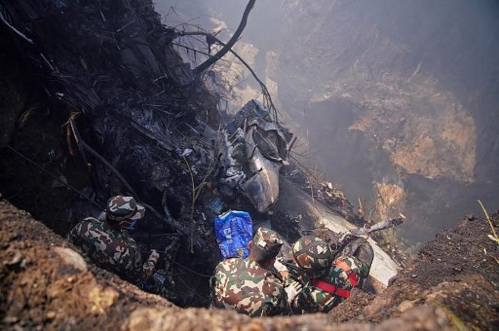 Petugas berada di lokasi jatuhnya pesawat Yeti Airlines di Pokhara, Nepal, 15 Januari 2023. (Yunish Gurung /AFP)