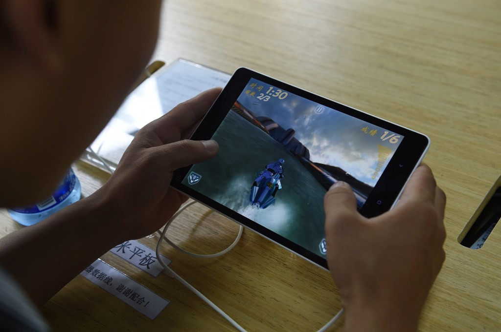 Ilustrasi seorang pelajar bermain game menggunakan tablet/AFP_GREG BAKER