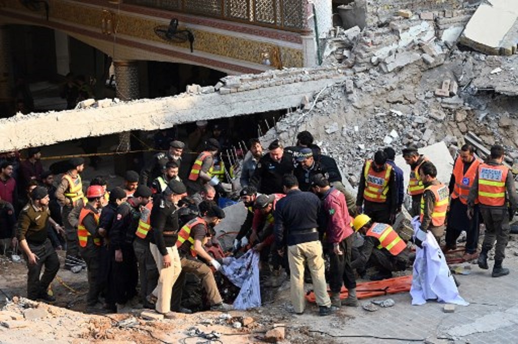 Petugas mengevakuasi jasad korban ledakan di reruntuhan sebuah masjid di Peshawar, Pakistan, 30 Januari 2023. (Abdul MAJEED / AFP)
