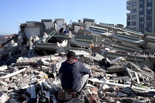 Seorang pria melihat puing bangunan yang hancur akibat gempa di Kahramanmaras, Turki. Foto: AFP