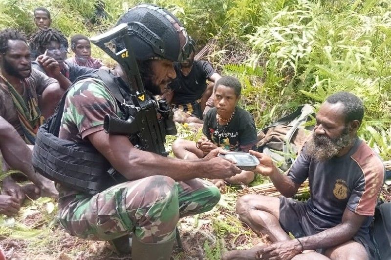 Prajurit TNI sedang membantu warga yang mengungsi ke Kenyam. (ANTARA/HO-Yonif Raider 514/SY)