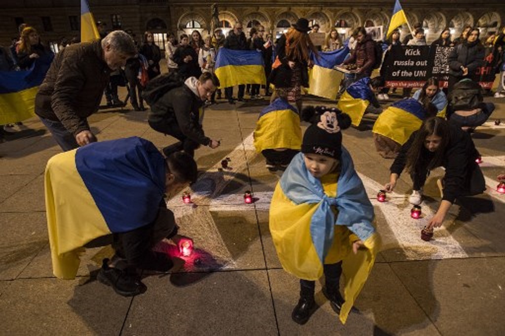 Warga Ukraina yang tinggal di Republik Cek menuliskan kata Anak-Anak dalam Bahasa Rusia di Praha, 18 Maret 2023. (Michal Cizek / AFP)