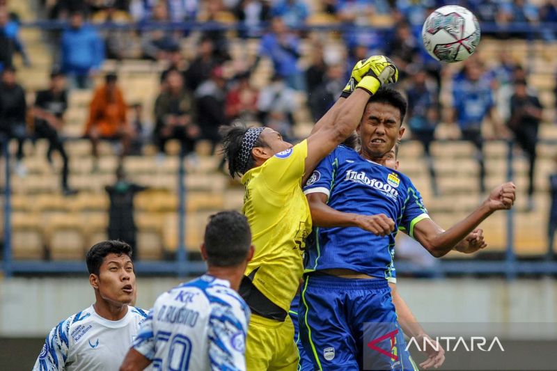 Pesepak bola Persib Bandung Kakang Rudianto (kanan) berebut bola atas dengan penjaga gawang PSIS Semarang Wahyu Tri. (ANTARA FOTO/Raisan Al Farisi/aww)