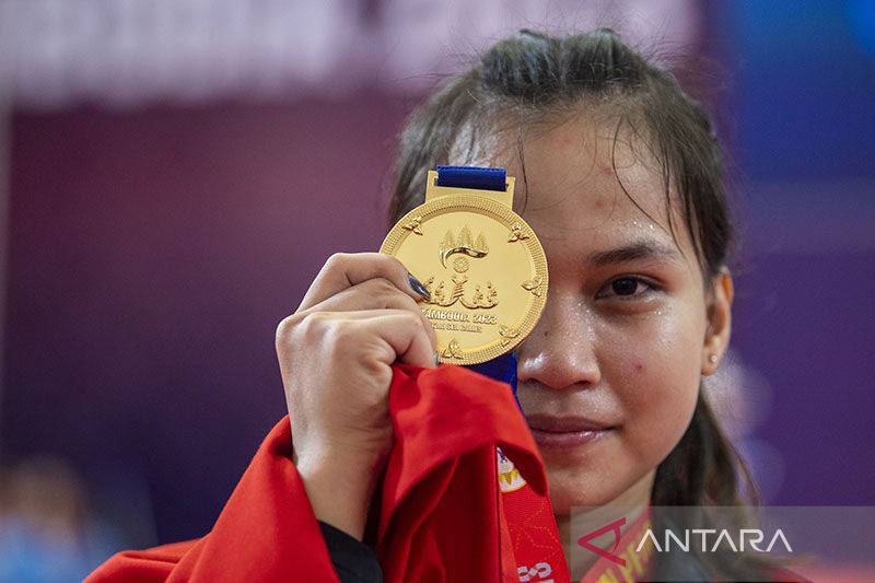 Atlet angkat besi Indonesia Juliana Klarisa menunjukan medali emas SEA Games 2023. (ANTARA FOTO/M Agung Rajasa)