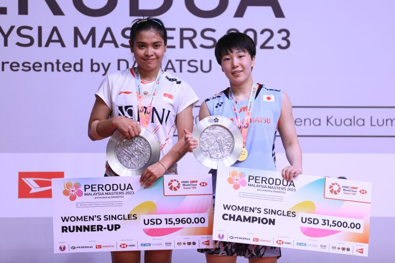  Gregoria Mariska Tunjung saat menaiki podium penyerahan hadiah Malaysia Masters 2023 bersama sang juara Akane Yamaguchi (kanan) di Kuala Lumpur, Minggu. (ANTARA/HO-PP PBSI)