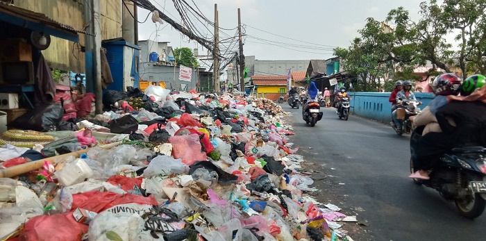 Sampah yang menggunung hingga berserakan ke jalanan terlihat menghiasi jalan penghubung Tangerang dan Jakarta Barat di Jalan KH Ahmad Dahlan, Kecamatan Cipondoh, Kota Tangerang.