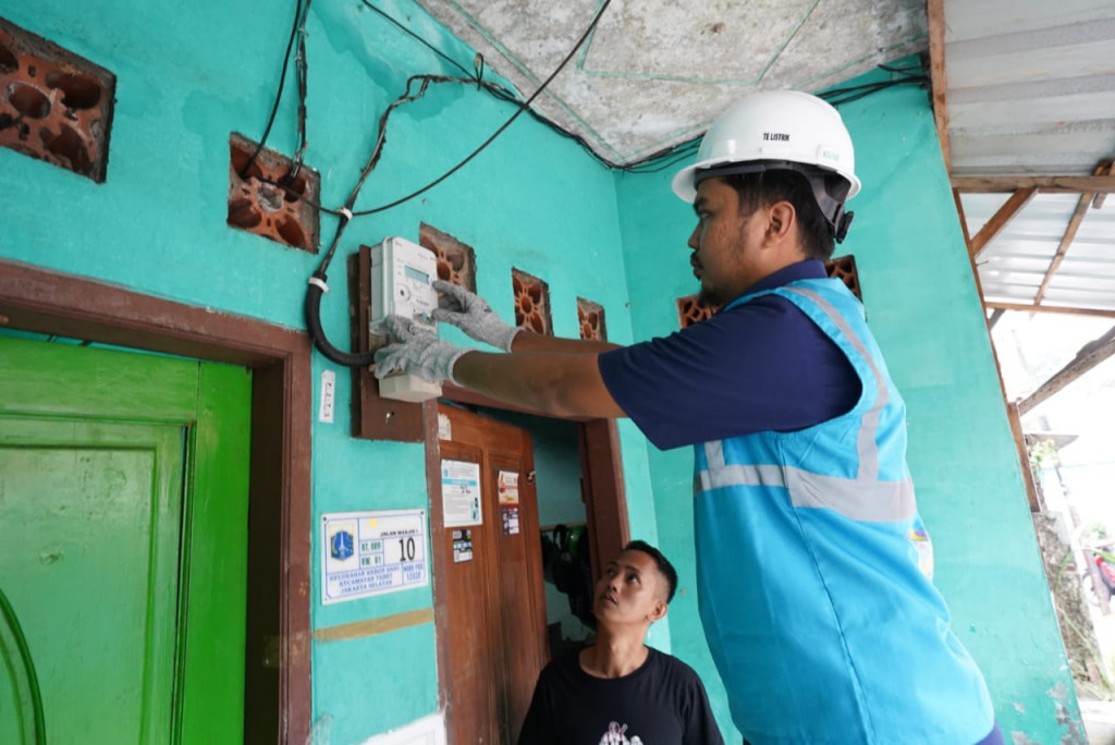 Petugas PLN melakukan penggantian kWh meter ke smart meter di salah satu bangunan pelanggan di Jakarta.