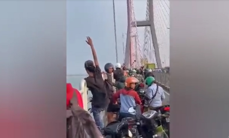 Potongan layar detik-detik seorang pria bunuh diri dengan cara melompat dari Jembatan Suramadu (Foto / Istimewa)