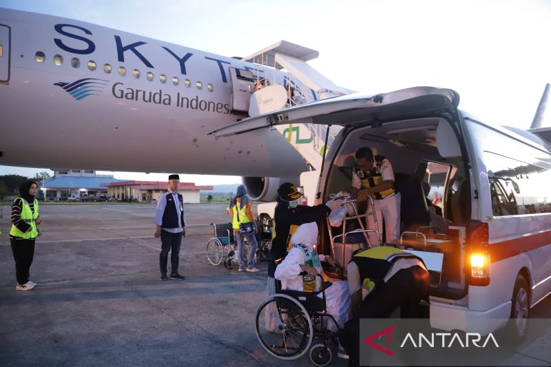 Petugas membantu jamaah haji kelompok terbang (kloter) ketiga saat tiba di Bandara Internasional Sultan Iskandar Muda (SIM), Aceh Besar, Aceh, Jumat (7/7/2023). (ANTARA/HO-PPIH Embarkasi Aceh)
