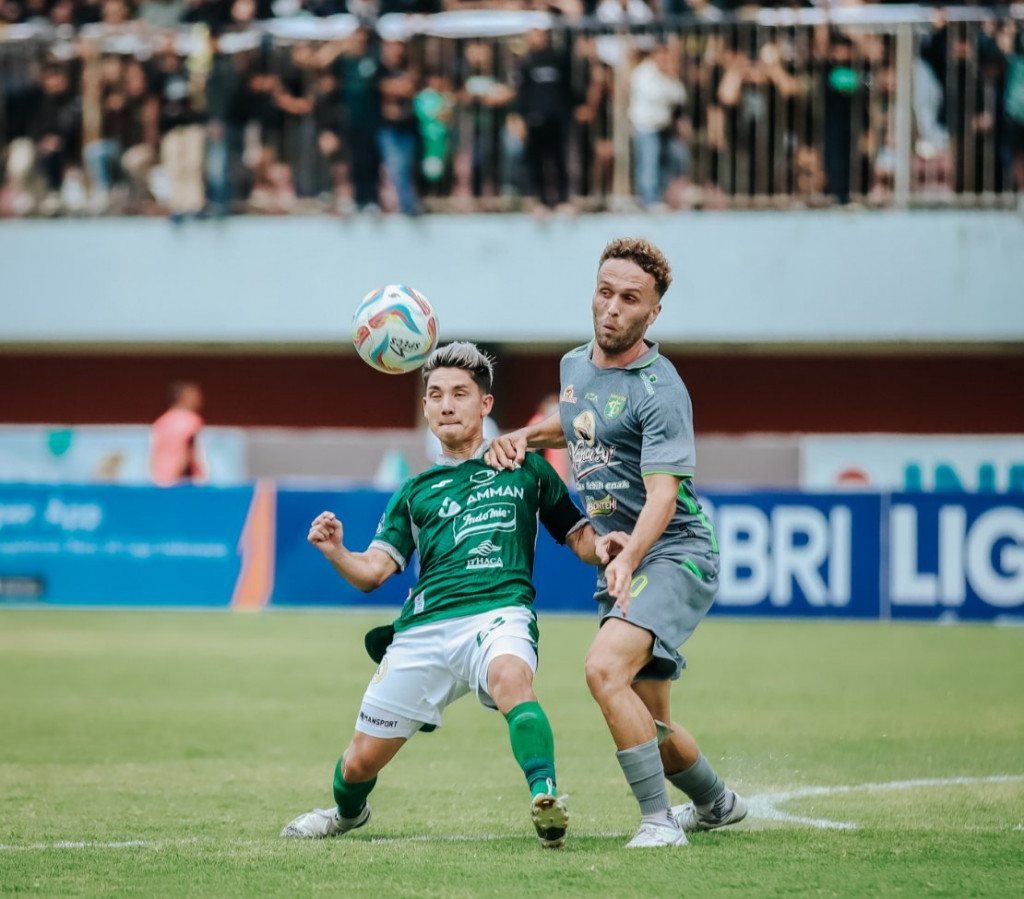 Pemain PSS Sleman, Kim Kurniawan (berkostum hijau) saat menjaga bola dari gangguan pemain Persebaya, Ze Valente. (Foto: Istimewa)