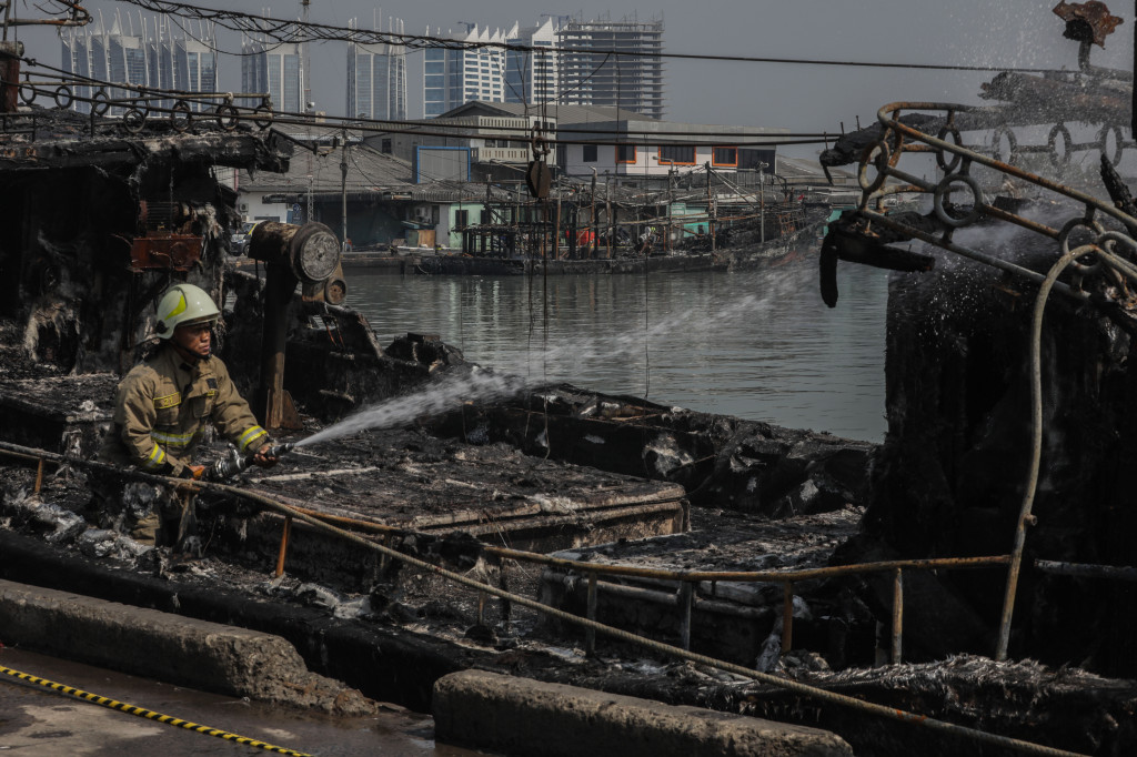 Potret Petugas Lakukan Pendinginan Kebakaran 9 Kapal di Muara Baru