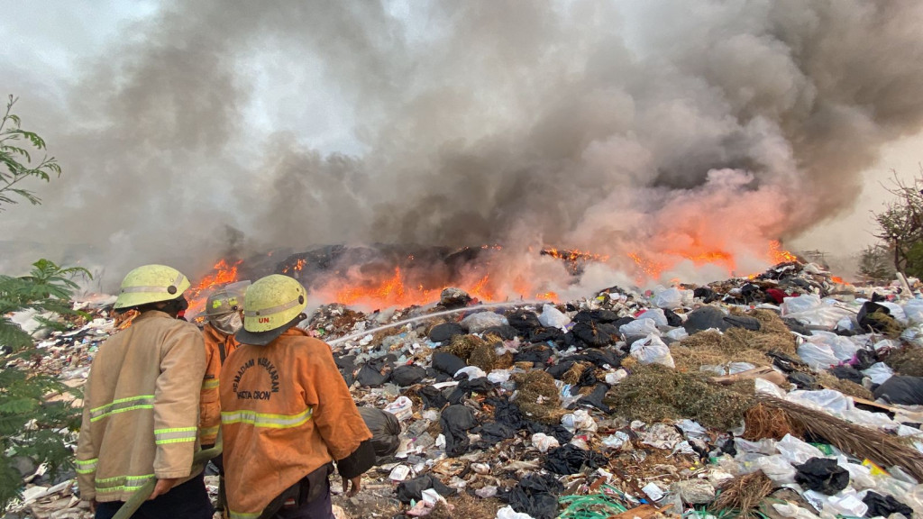 Petugas sedang berusaha memadamkan api yang membakar TPA Kopi Luhur Kota Cirebon.