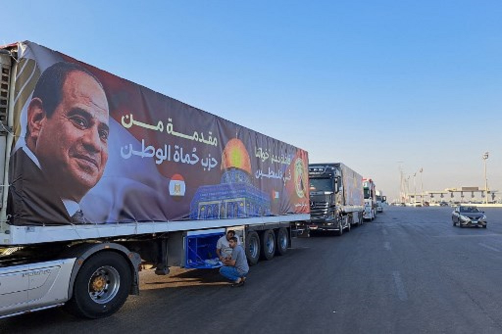 Sejumlah truk terlihat menanti instruksi dalam perjalanan menuju titik penyeberangan Rafah untuk menyalurkan bantuan kemanusiaan ke Jalur Gaza, 16 Oktober 2023. (Khaled DESOUKI / AFP)