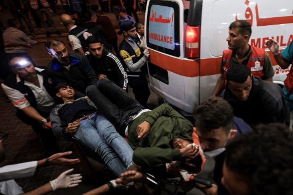 Warga Palestina mengevakuasi dua korban luka serangan udara Israel di Khan Younis, Jalur Gaza, 18 Oktober 2023. (Mahmud HAMS / AFP)