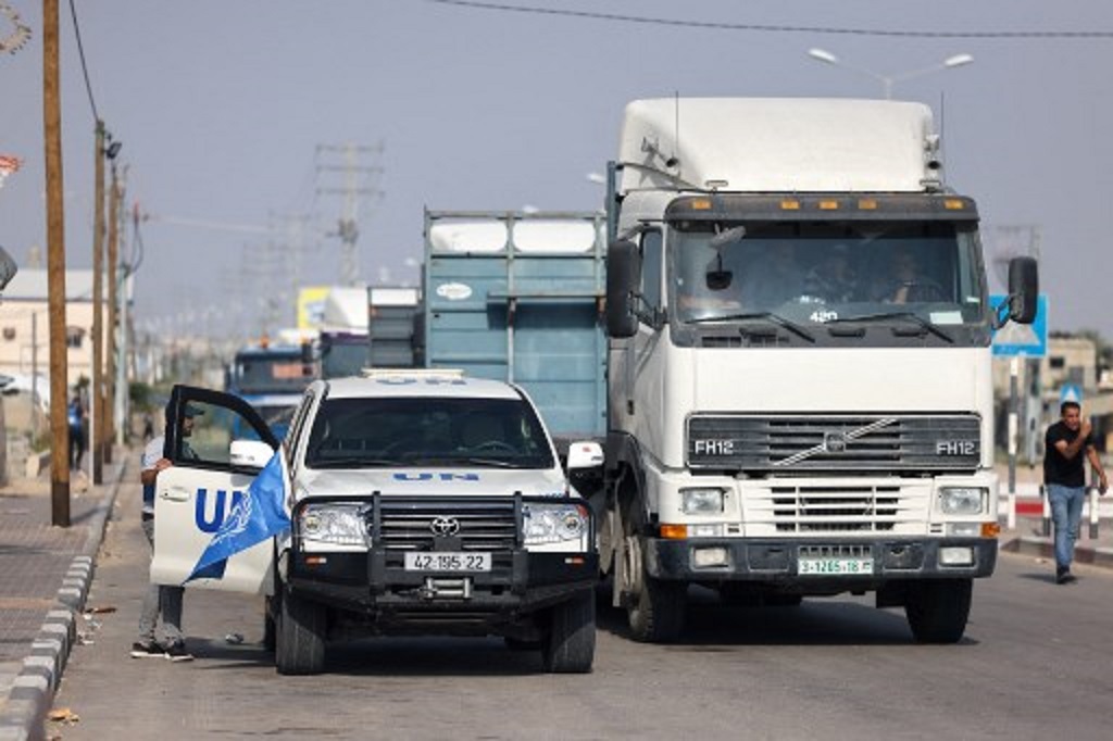 Konvoi truk yang hendak membawa bantuan kemanusiaan untuk Gaza menanti izin di titik penyeberangan Rafah, 22 Oktober 2023. (MOHAMMED ABED / AFP)