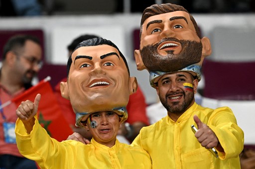 Suporter sepak bola mengenakan topeng Cristiano Ronaldo dan Lionel Messi. (Paul ELLIS / AFP)