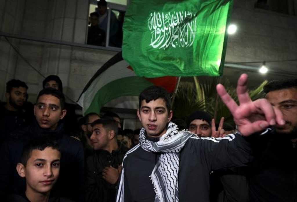 Satu dari 39 tahanan Palestina yang dibebaskan Israel berpose di depan kamera di dekat rumahnya di Hebron pada Senin dini hari, 27 November 2023. (HAZEM BADER / AFP)