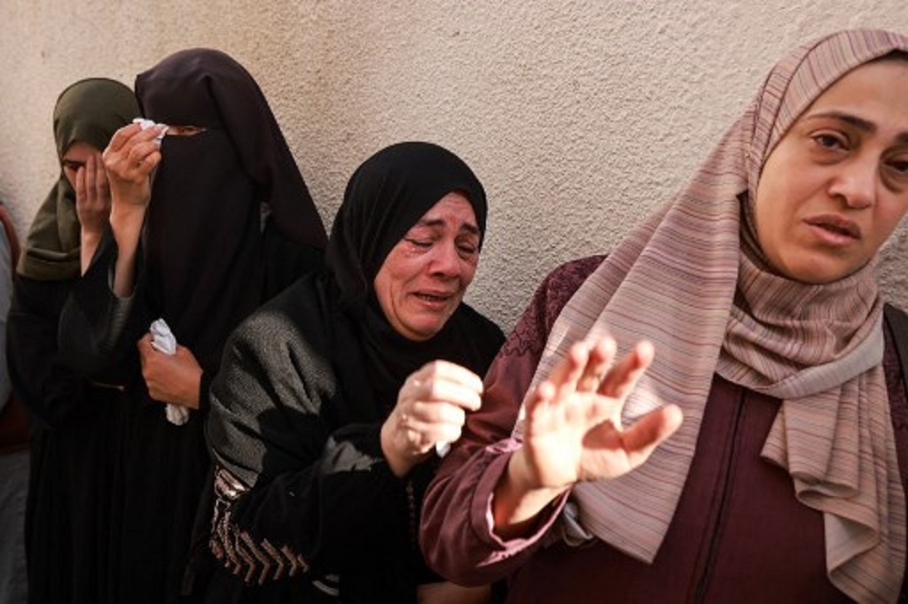 Sekelompok perempuan Palestina berduka atas kematian kerabat mereka dalam serangan udara Israel di Jalur Gaza, 4 Desember 2023. (MOHAMMED ABED / AFP)