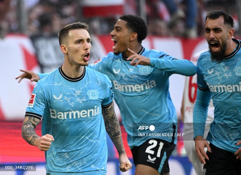 Bek Bayer Leverkusen, Alex Grimaldo, merayakan gol ke gawang Koeln (AFP/Ina Fassbender)