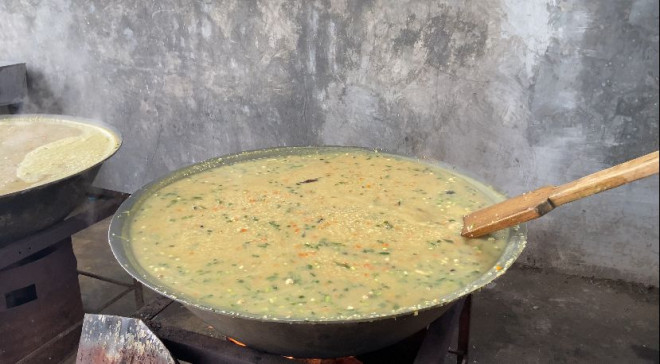 Pemuda Desa Bueng Bak Jok memasak bubur dalam belanga besar di meunasah (musala). Foto: Medcom.id/Fajri Fatmawati