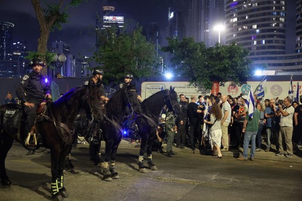 Aparat keamanan Israel menghadapi demonstran yang mengikuti aksi menuntut pembebasan sandera di Tel Aviv, 4 Mei 2024. (JACK GUEZ / AFP)