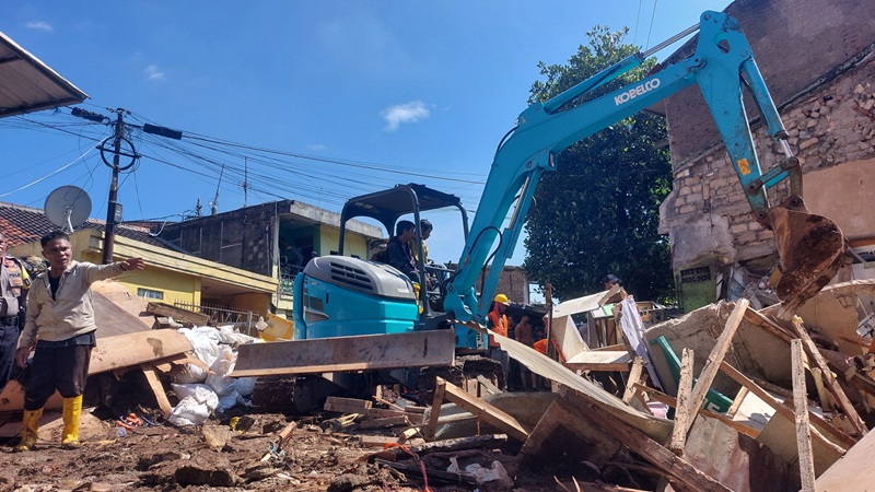 Alat berat dikerahkan untuk bersihkan puing-puing rumah yang rusak berat akibat pipa induk pecah milik Perumda Tirtawening Kota Bandung di Jalan Cibangkong Lor, Kelurahan Maleer, Kecamatan Batununggal pada Kamis, 6 Juni 2024.