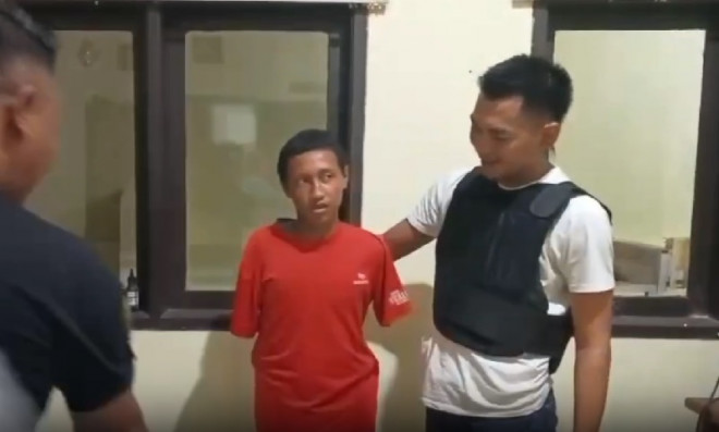 Pelaku mutiasi di Garut, Jawa Barat, mengenakan baju tahanan dengan tangan terborgol. (MGN/Wildan Fadilah)