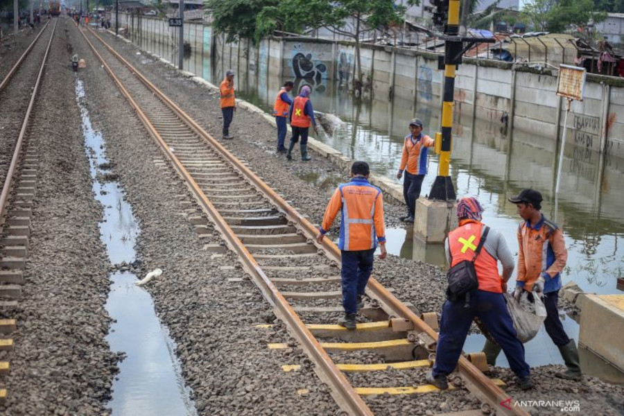 Petugas memperbaiki jalur kereta yang sempat terendam banjir. Branda Antara