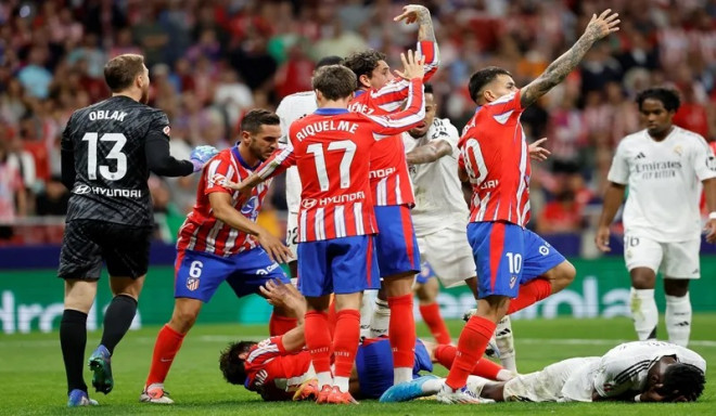 Bek Atletico Madrid Robin le Normand dan gelandang Real Madrid Aurelien Tchouameni terkapar di lapangan usai berbenturan kepala di laga La Liga.(AFP/OSCAR DEL POZO)