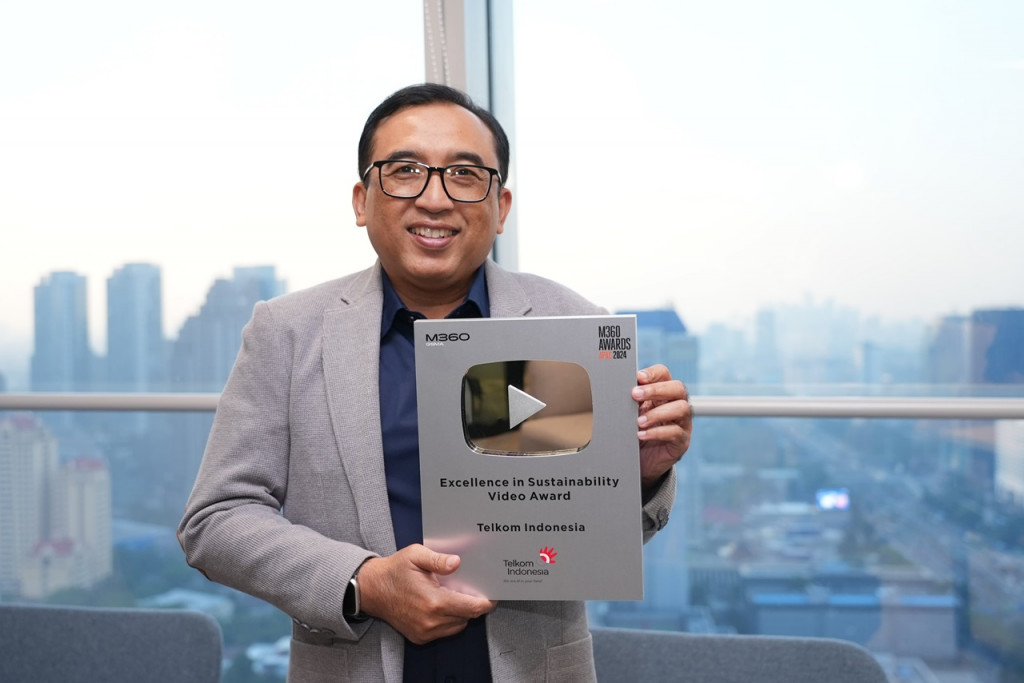 VP Corporate Communication Telkom Andri Herawan Sasoko menunjukkan trofi M360 Digital Nations Awards 2024. 