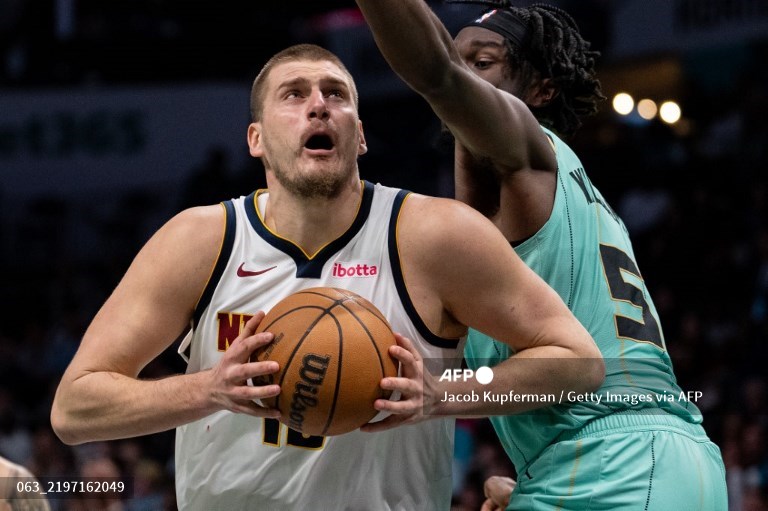 Center Denver Nuggets, Nikola Jokic, mencoba melewati hadangan center Charlotte Hornets, Mark Williams (AFP/Jacob Kupferman)