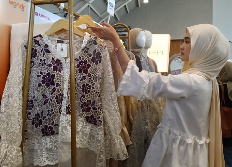 Pengunjung bazaar GlamLocal di PIM 3 sedang memilih atasan katbol dengan bordir bunga. (Foto: Dok. Yuni)