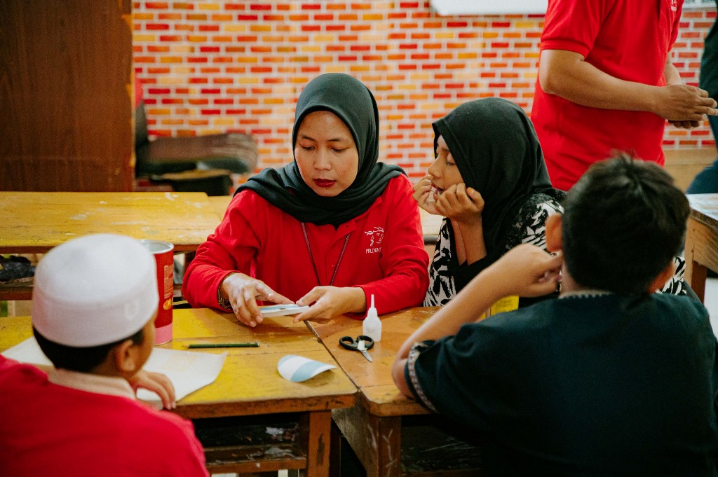 PRUVolunteers mengajak bermain dan mengajar murid-murid sekolah dasar tentang cara sederhana mengatur keuangan dengan bijak. Dok. Ist