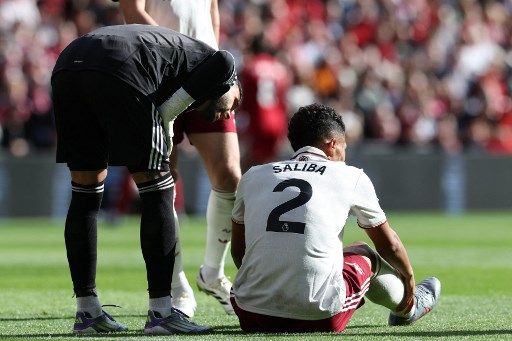 Bek Arsenal, William Saliba, memegangi engkelnya yang cedera ketika menghadapi Liverpool (AFP/Darren Staples)