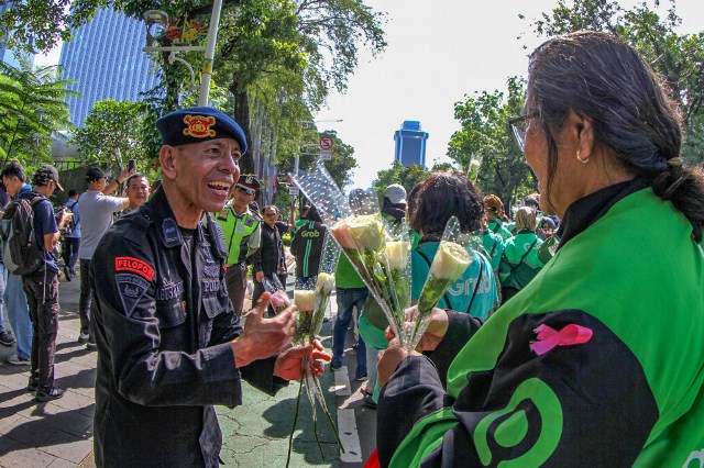 Aksi damai Ojol bagikan bunga berwarna putih. (Foto: Dok. MI/Usman Iskandar)