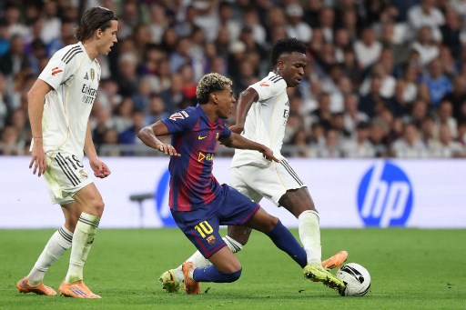 Winger Real Madrid, Vinicius Junior, merebut bola dari winger Barcelona, Lamine Yamal (AFP/Oscar Del Pozo)