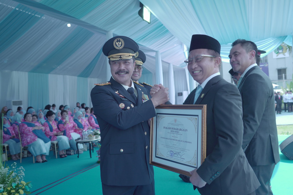 Menteri Imigrasi dan Pemasyarakatan RI, Agus Andrianto (depan kiri) ketika memberikan piagam penghargaan kepada Direktur Retail dan Niaga PLN, Adi Priyanto (depan kanan) atas komitmen PLN dalam memberdayakan warga binaan Lapas Nusakambangan melalui Progra