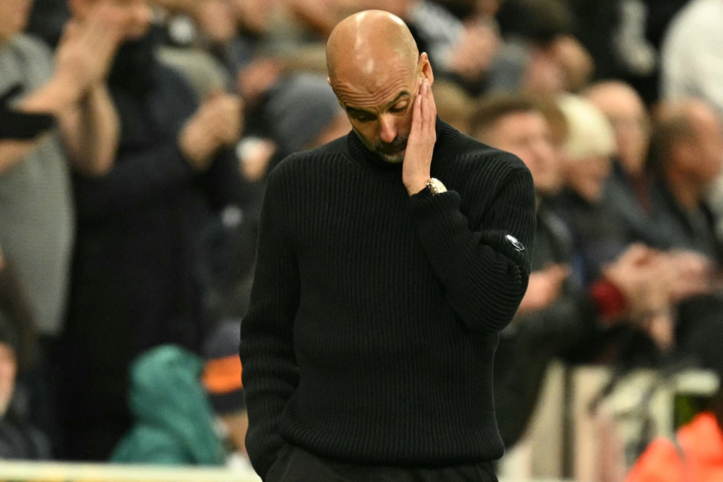 Pelatih Manchester City, Pep Guardiola, tertunduk lesu usai timnya dikalahkan Newcastle United (AFP/Oli Scarff)