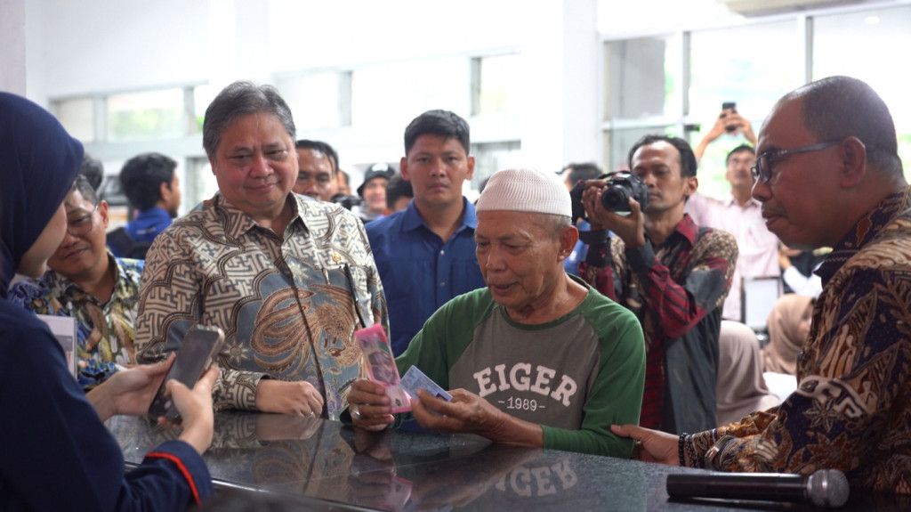 Menteri Koordinator Bidang Perekonomian Airlangga Hartarto dan Plt Direktur Utama PosIND, Haris bersama salah satu Keluarga Penerima Manfaat (KPM) BLTS Kesra di Kantorpos KCU Premier, Jakarta Timur.