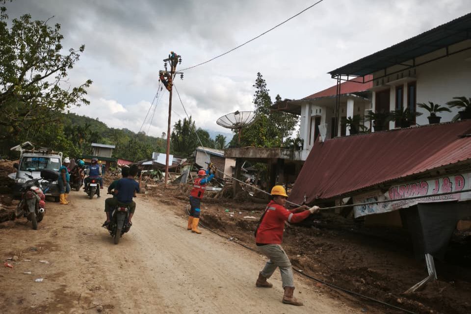 Petugas PLN melakukan penarikan kabel untuk disambungkan ke tiang-tiang listrik jaringan tegangan rendah (JTR) baru di Kabupaten Agam. Foto: Dokumen PLN