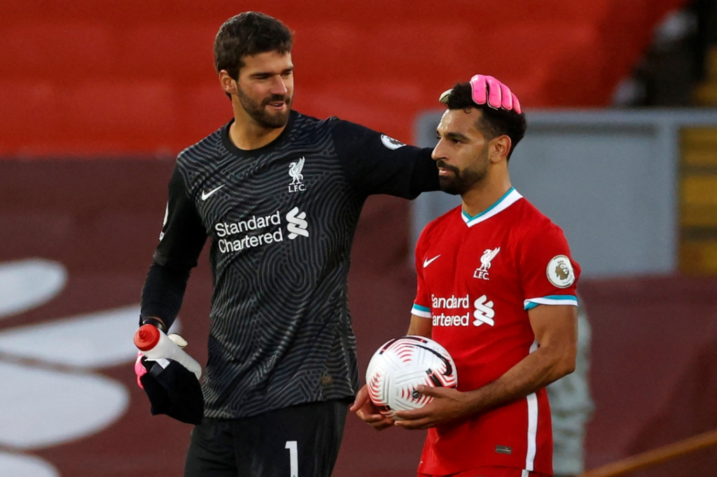 Kiper Liverpool, Alisson Becker, bersama winger Liverpool, Mohamed Salah (AFP/Phil Noble)